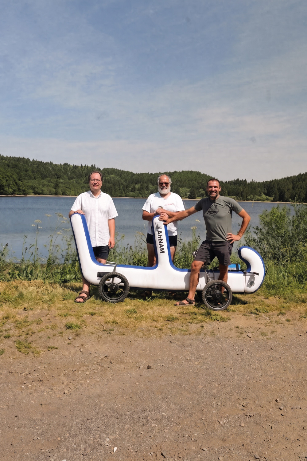 Trois membres de l'équipe AirNAM posant avec La Fourmi, bord de lac